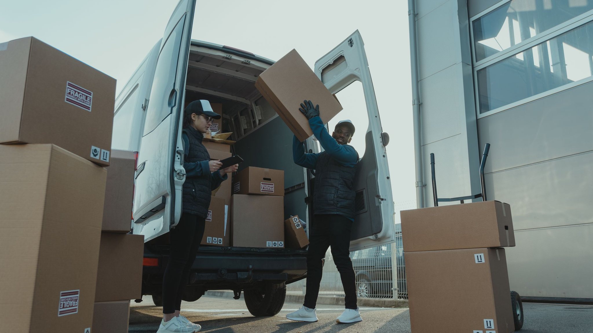 Delivery driver unloading boxes from a van